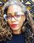 Headshot of a woman wearing glasses. African mudcloth in background.